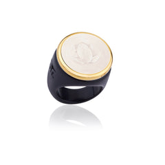 Ring with gold and black band featuring a white engraved face on a white background