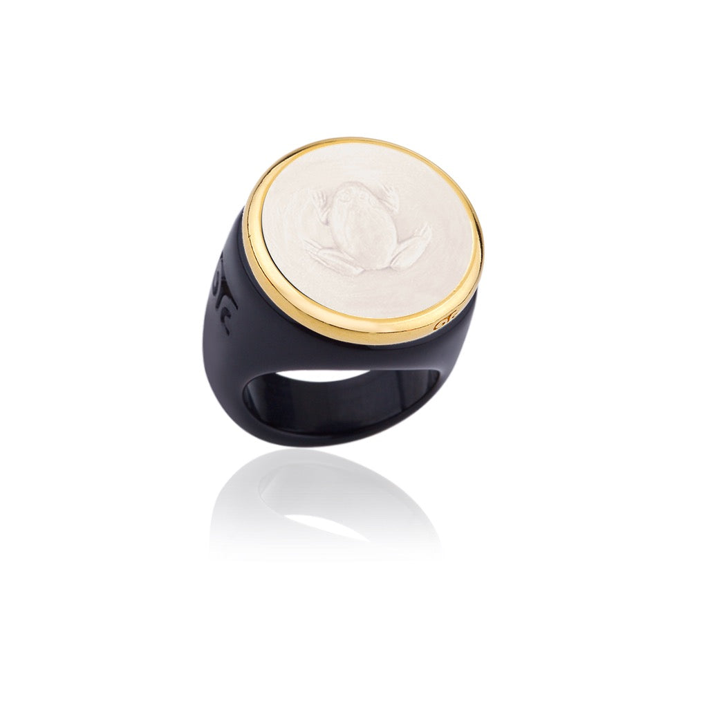 Ring with gold and black band featuring a white engraved face on a white background