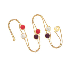 Gold chain necklace with colorful round pendants on a white background