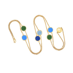 Gold necklace with colorful round pendants on a white background